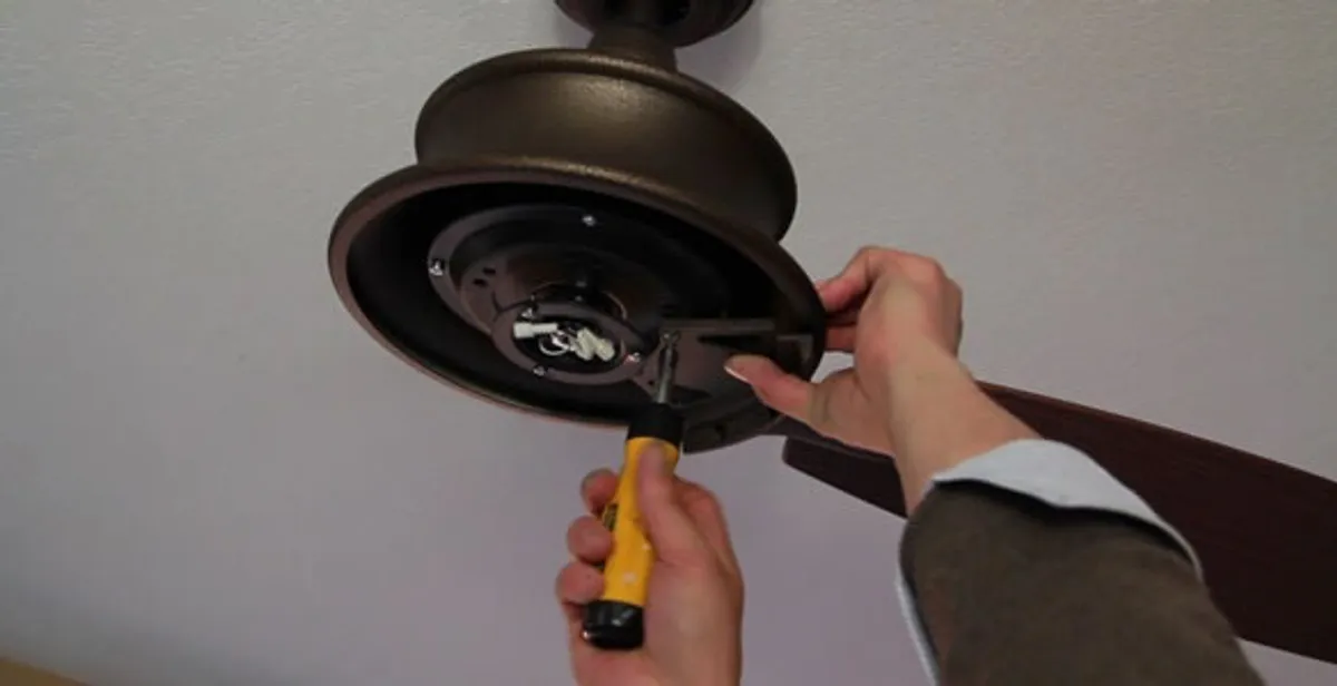 Electrician installing ceiling fan mounting bracket and fixture in Evansville, IN