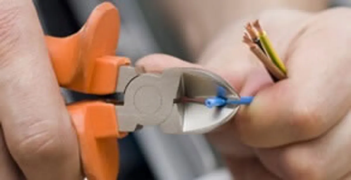 licensed electrician performing precise wire cutting and preparation during electrical service in Evansville, IN